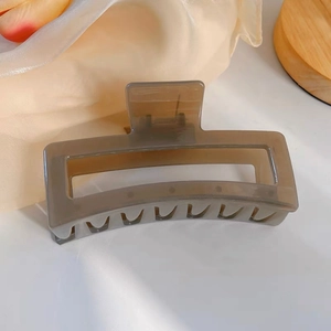 Détail d'une grande pince à cheveux rectangulaire taupe sur un fond de soie élégant