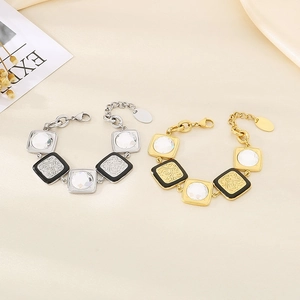 Dettaglio di bracciali vintage in oro e argento con ciondoli in smalto e cristallo