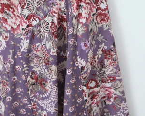 Détail du tissu patchwork violet vintage avec des motifs floraux rouges et blancs