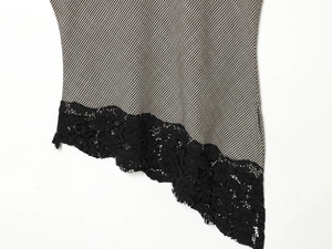 Detail of houndstooth fabric with black floral lace trim and intricate hollow embroidery