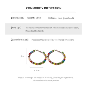 Detail view of colorful beaded hoop earrings featuring vibrant glass beads on silver pins