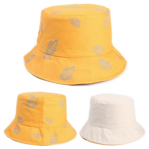 Détails d'un bob réversible avec imprimé papillon jaune et textures en toile crème