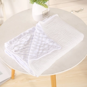 Detailed shot of white double-sided minky dotted and cotton gauze baby blanket.