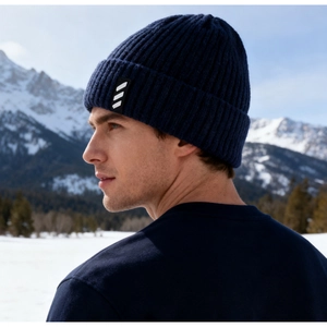 Macro detail of dark blue ribbed knit winter beanie with athletic logo patch outdoors