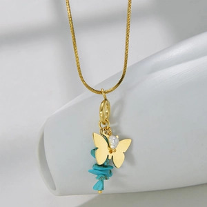 Detail of gold butterfly pendant necklace with blue stones and pearl on snake chain