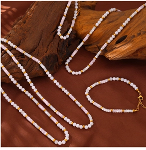 Macro view of shell beaded necklace and bracelet set on brown satin background