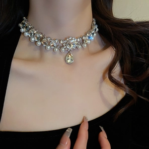 Close-up of pearl and rhinestone flower necklace with teardrop pendant on model