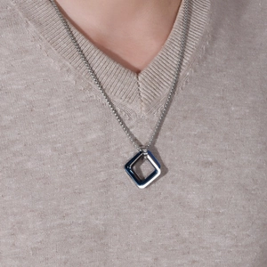Detail of hip hop geometric square pendants in silver and blue on a long chain