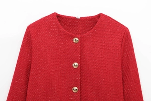 Macro detail of red tweed fabric texture and gold buttons on a round neck jacket