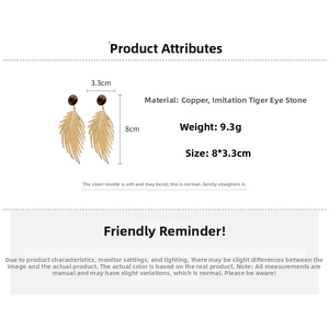 Detail view of gold feather earrings with tiger eye stone and exact measurements