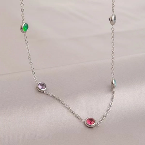 Elegant gold-plated necklace with colorful zircon stones on a soft satin background