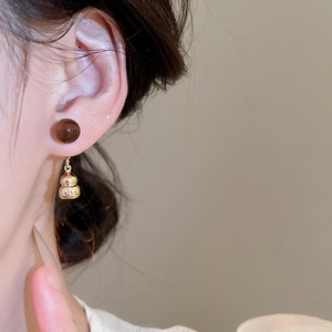 Close-up of model wearing retro gold gourd drop earrings with red stone and zircon
