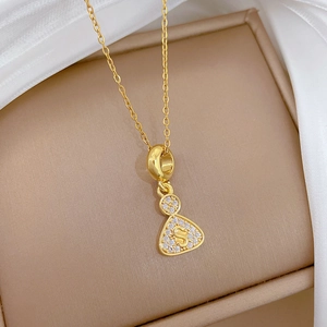 Macro shot of gold-plated pendant with sparkling pavé crystals and an S-letter detail