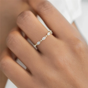 Detailed macro view of a gold-tone luxury ring with marquise and round white crystals