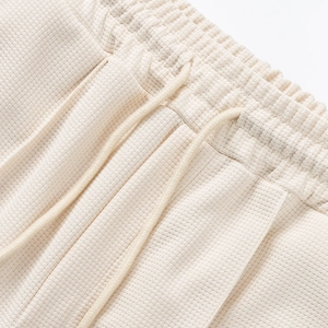 Detalle de pantalones cortos de punto gofrado con cintura elástica y cordón ajustable