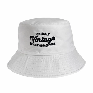 Close-up of vintage black embroidery on a white cotton reversible bucket hat fabric