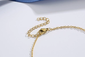 Detail of the golden titanium lobster clasp and extension chain on white background