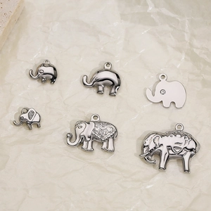 Polished silver elephant pendants in various carved and diamond-set styles on paper