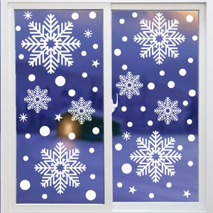 Close-up of white snowflake static window decals applied on glass for Christmas decor