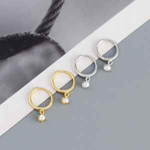 Detailed view of minimalist gold and silver hoop earrings with white pearl pendants