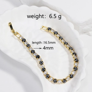Detail of 4mm tennis bracelet with gold devil's eye charms and round cubic zirconia