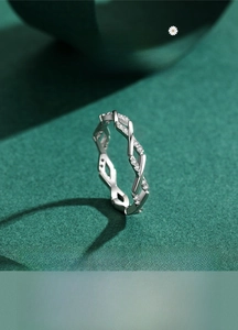 Macro detail of intertwined S925 sterling silver ring with micro-pave geometric zircon stones