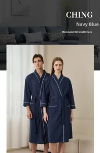 Detail of navy blue robe showing 3D grid texture, white piping, and belt on long sleeves