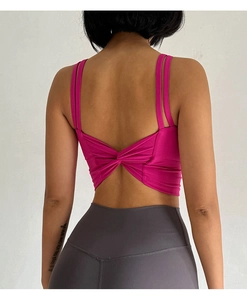 Detail of rose red sports bra with criss-cross back design and high waist grey leggings