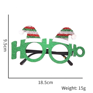 Close-up of green glitter HO HO HO Christmas glasses frame with mini Santa hats