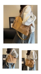 Detail of khaki nylon tote bag with dual zippers and adjustable shoulder strap