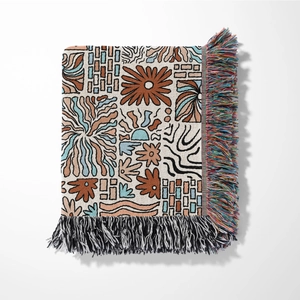 Detailed view of bohemian jacquard blanket with floral patterns and colorful tassels