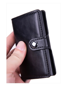 Macro detail of black leather RFID wallet with reinforced stitching and metal snap closure