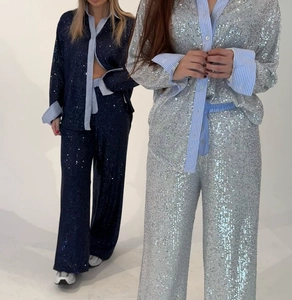 Detail of blue sequin blazer and wide-leg trousers set with striped patchwork collar
