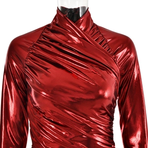 Detail van de rode metallic PU-lederen textuur en geplooide stof van de jurk met lange mouwen