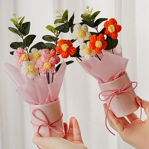 Detailansicht handgefertigter Häkelblumen in einem rosa Geschenkeimer mit Schleife.