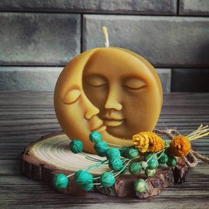 Artistieke zon en maan gezicht kaars op houten schijf met droogbloemen decor