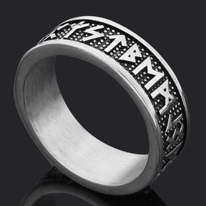 Macro shot of Viking runes engraved on a vintage silver steel ring with brushed texture