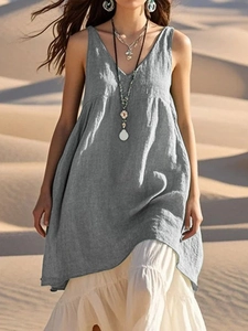 Detail of grey sleeveless cotton linen V-neck dress over white layered skirt in desert