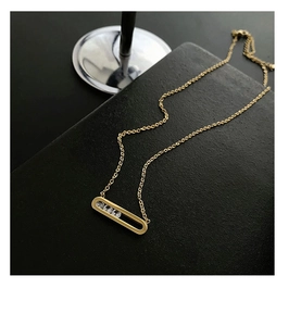 Detail of 18K gold plated necklace featuring rectangular pendant with moving zircons