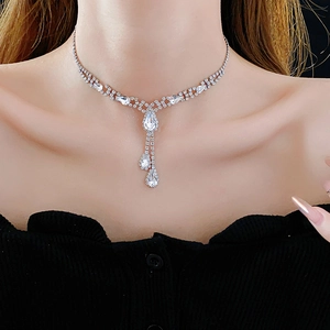 Close-up of elegant Y-shaped silver necklace with teardrop diamonds on a model