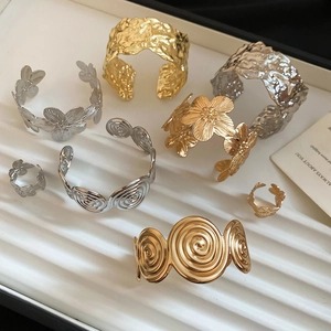Macro shot of gold and silver textured metal bracelets with spiral flower details