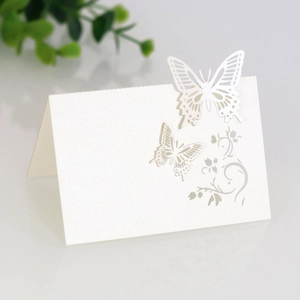 Detail of white laser-cut butterfly place card with elegant hollowed-out paper texture