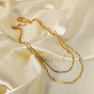 Dettaglio della collana a tre strati in acciaio dorato 18K con perle su seta
