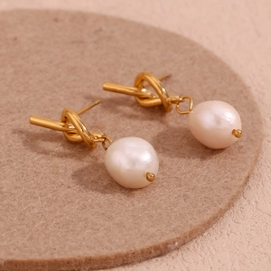 Detail shot of 18K gold plated knotted metal stud earrings with freshwater pearls