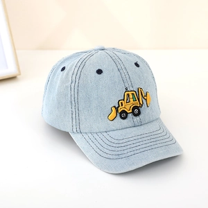 Detailed close-up of yellow excavator embroidery on light blue denim kids baseball cap