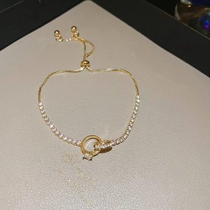 Detail of adjustable gold-plated bracelet featuring interlocking rings and cubic zirconia