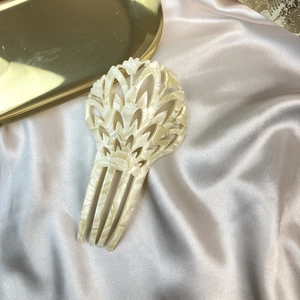 Elegant cream marble acetate 4-tooth hair comb with cutout leaf design on silk