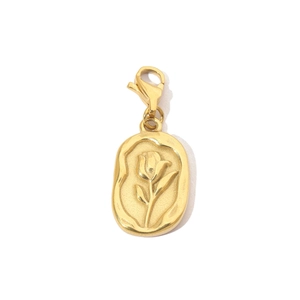 Macro view of gold stainless steel oval pendant with floral engraving and lobster clasp
