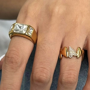 Detail of 18k gold irregular heart ring and rectangular zircon ring on fingers