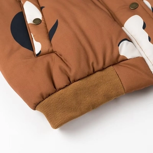 Detailansicht der braunen Jacke mit Kuhmuster, Rippbündchen und Vintage-Druckknöpfen